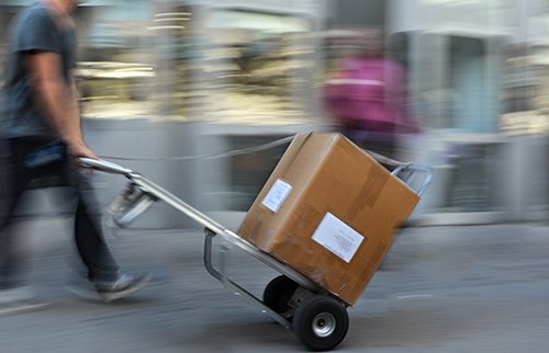 Blurry picture man delivering urgent shipment on dolly